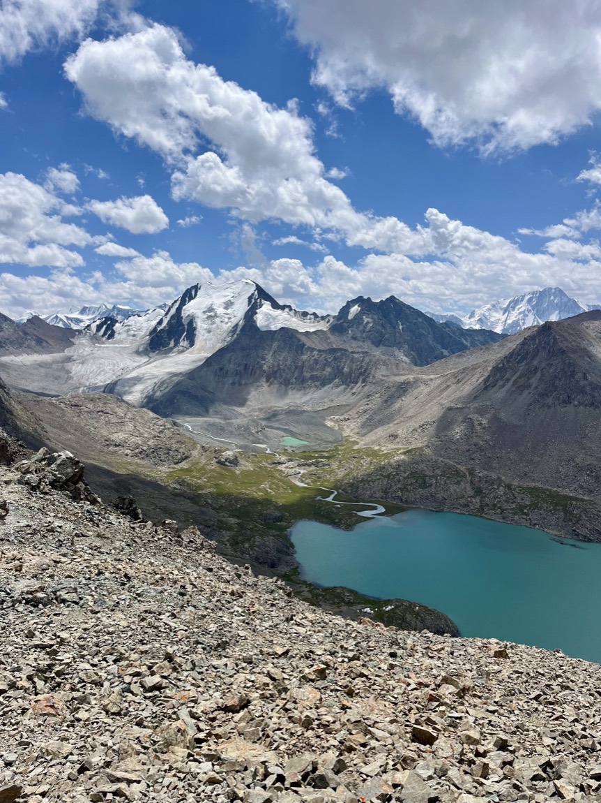 Ala-Kul alpine lake below snow-capped peaks in Kyrgyzstan